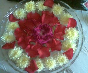 Rangoli: Glass bowl filled with water and flowers  