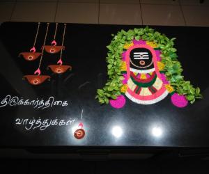 2021-Karthigai- Shivling with four diyas... The Tamil writing says "Thirukkarthigai Wishes"... ("Karthigai" is a festival of lights... that falls on a Poornima day after Diwali...)